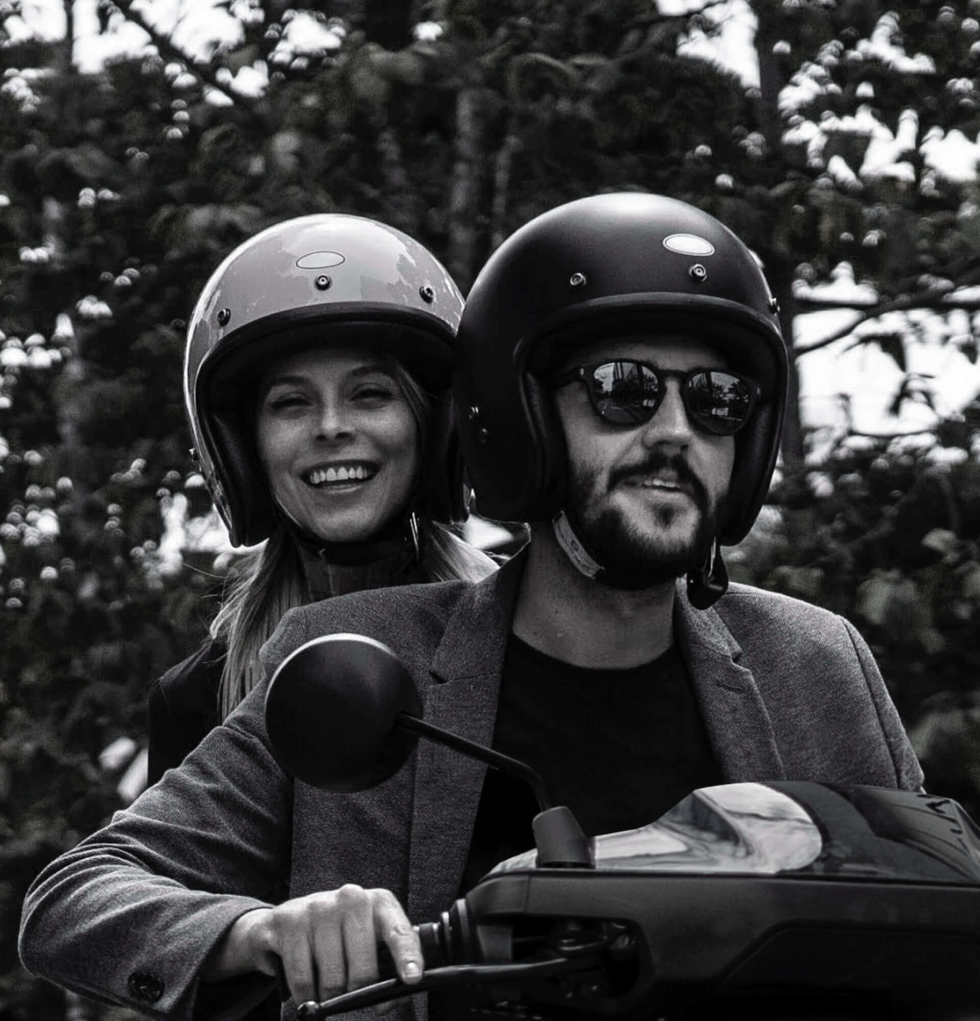 Schwarzweiss Bild von 2 Peronen mit Motorradhelm