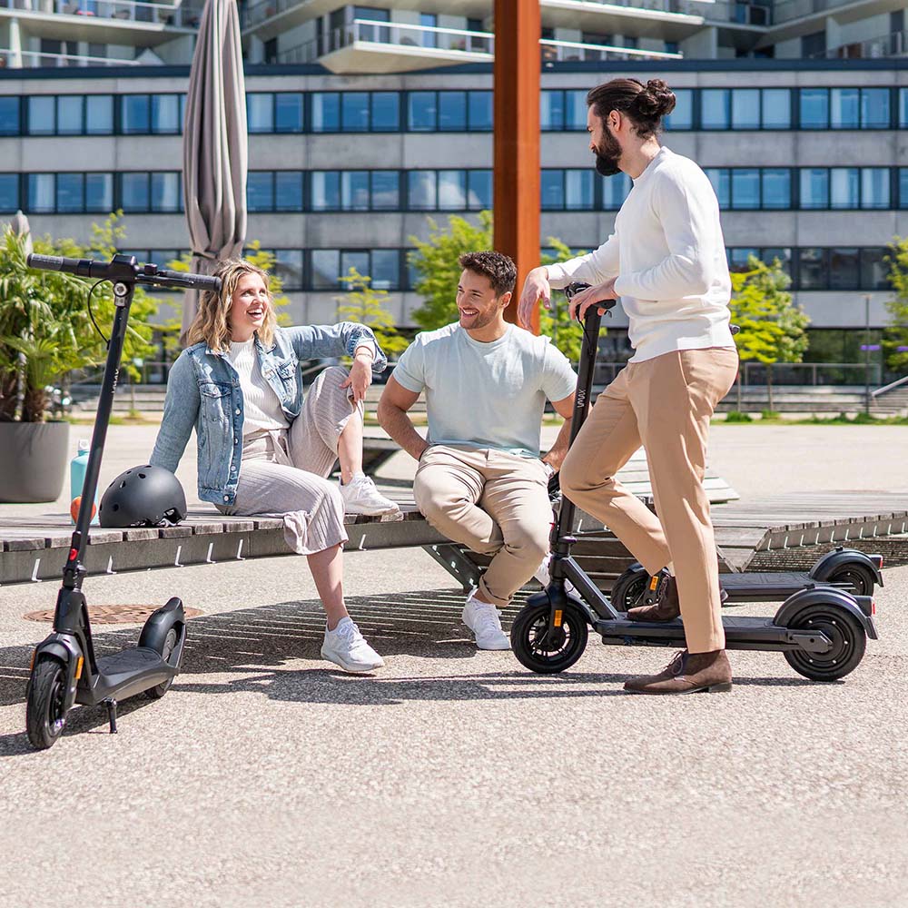 Gruppenbild mit drei Personen und eScootern VMAX VX2 in Parkanlage