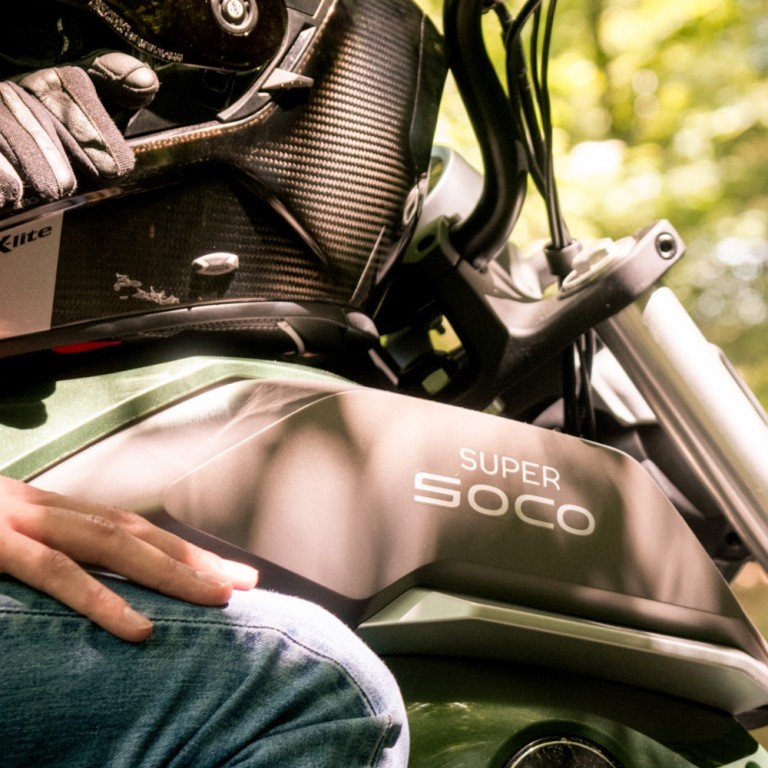 Elektromoped Super Soco TC Wanderer Tankansicht stehend mit Motorradhandschuhen und Helm